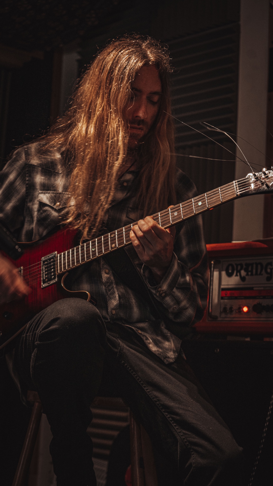 Jon playing electric guitar in a studio